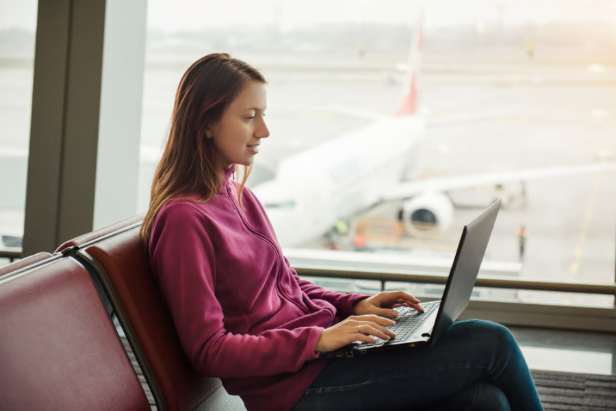 bahaya pakai publik wifi saat liburan ketika wisatawan mengakses internet melalui ponsel di bandara