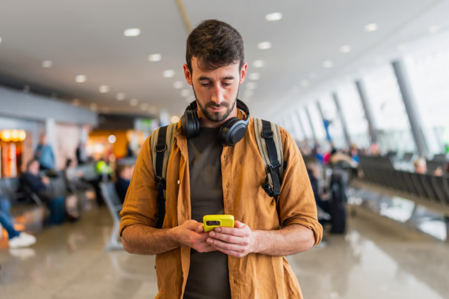 wisatawan menggunakan ponsel untuk menyiapkan konektivitas internet sebelum melakukan perjalanan ke luar negeri.