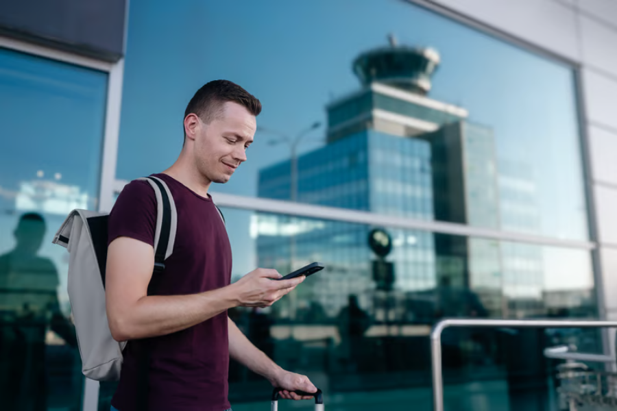 Wisatawan memeriksa koneksi internet pada ponsel saat bepergian ke luar negeri menggunakan eSIM.