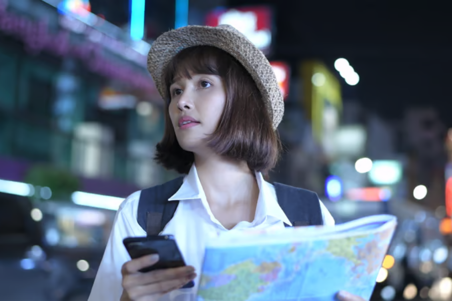 wisatawan menggunakan peta digital di ponsel untuk menemukan lokasi wisata dan menentukan rute selama liburan
