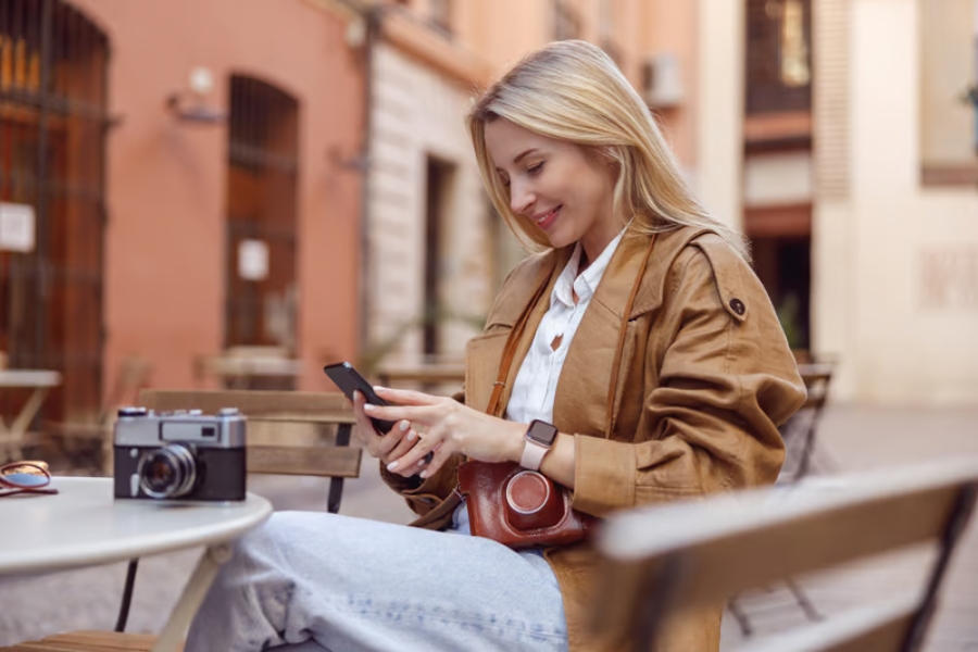 wisatawan menggunakan smartphone di kafe eropa untuk mencari informasi perjalanan dengan koneksi internet seluler.